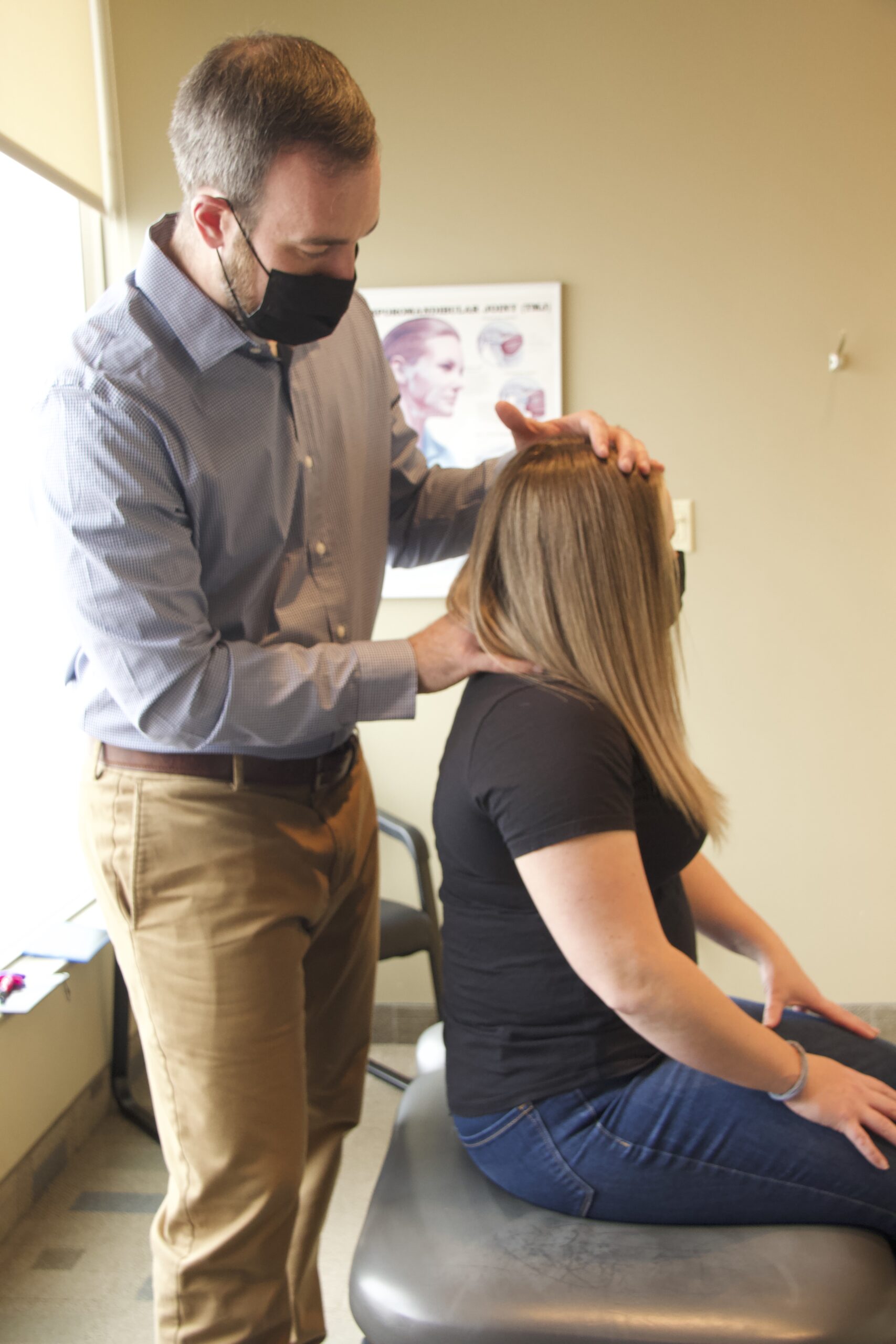 Dr. Tanti seated behind a patient examining their headache