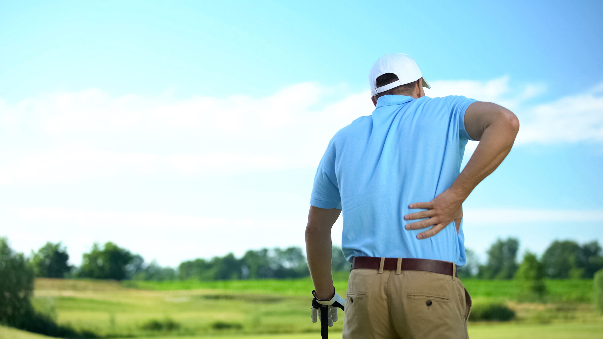 Golfer with low back pain and sciatic aafter hitting a golf ball