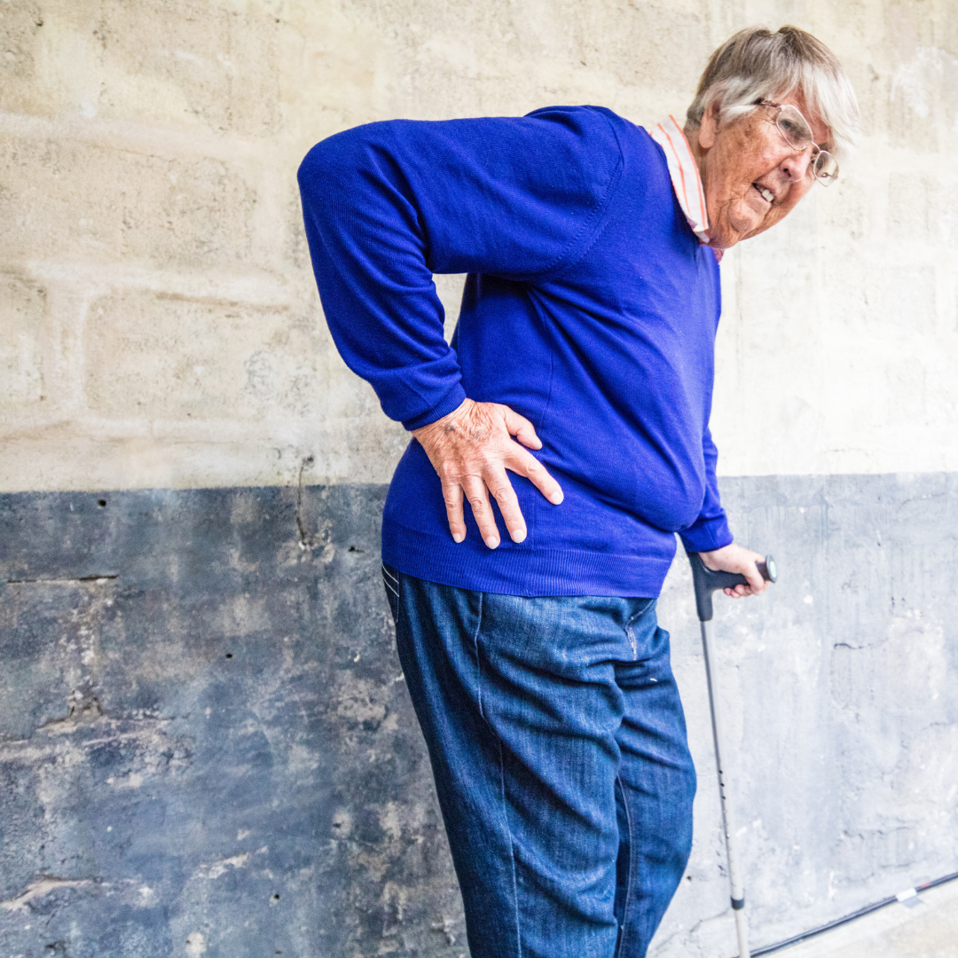 Elderly woman holding onto her right hip, and leaning on her cane, all because of arthritic hip pain