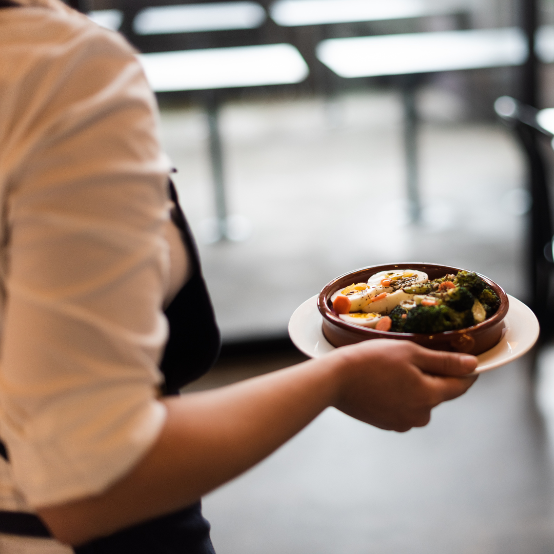 Waitress in a restaurant bringing out the customers soup dish