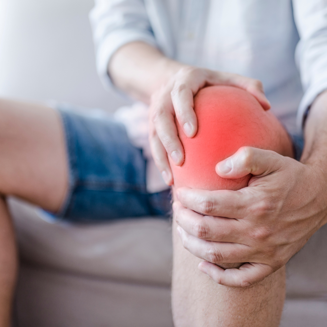 a man holding their painful knee due to knee bursitis