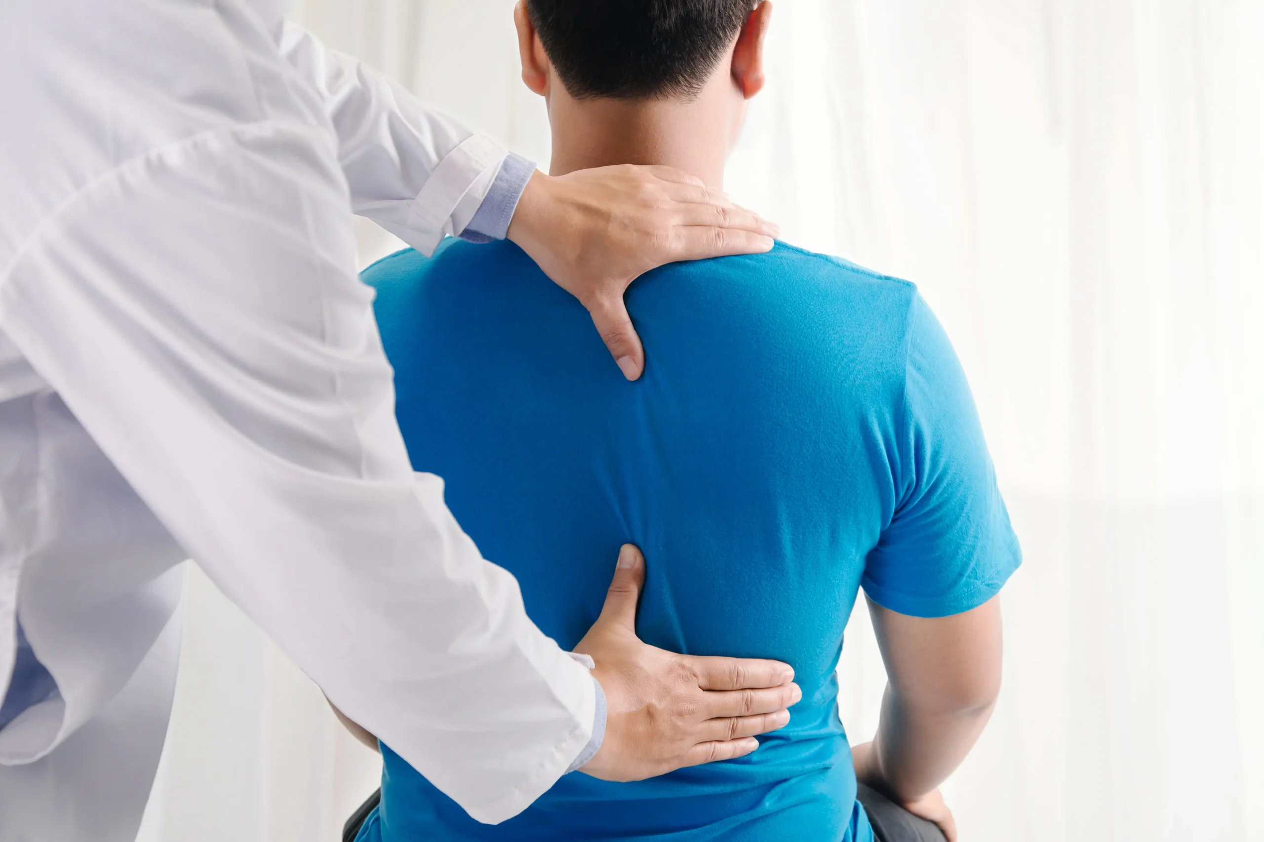 chiropractor evaluating a patients back