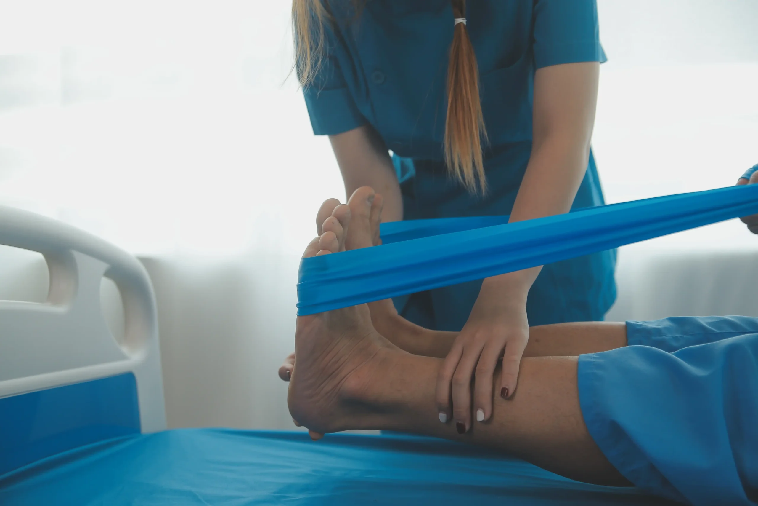 physiotherapist helping patient perform physiotherapy on their leg